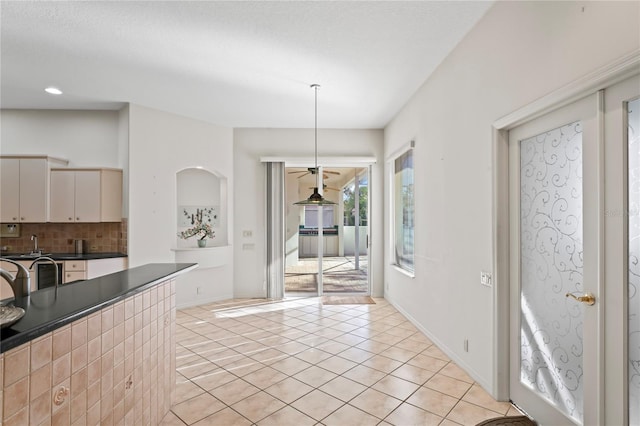 kitchen featuring backsplash, hanging light fixtures, and light tile patterned flooring