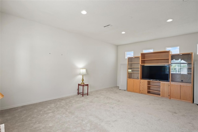 unfurnished living room with a wealth of natural light and light colored carpet