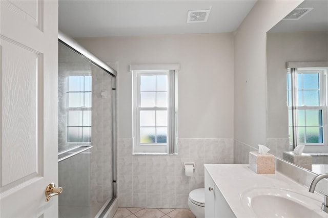 bathroom featuring tile patterned flooring, vanity, toilet, and an enclosed shower