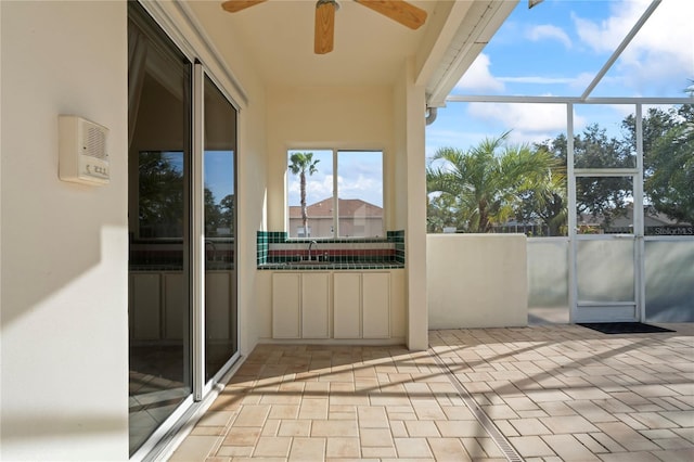 unfurnished sunroom featuring ceiling fan and sink