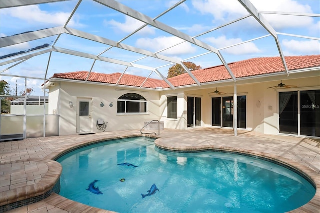 view of pool with glass enclosure, ceiling fan, and a patio