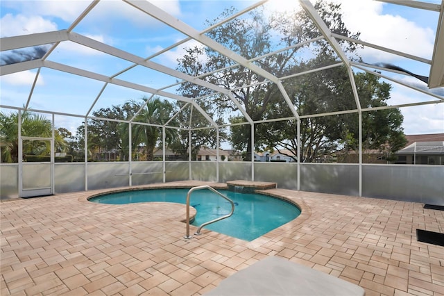 view of swimming pool featuring a patio area and glass enclosure