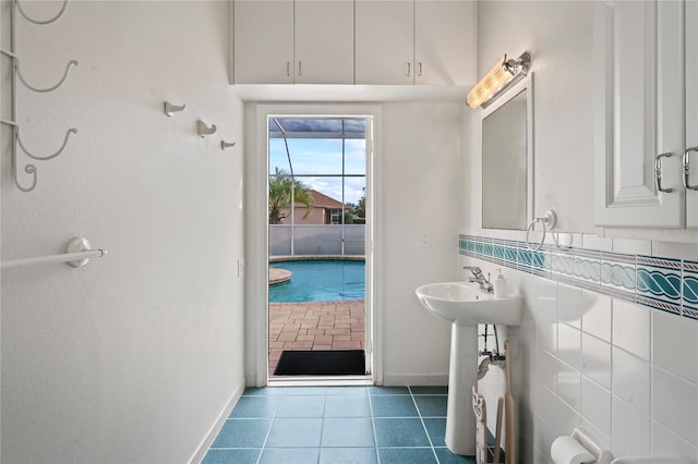 bathroom featuring tile patterned floors, sink, and tile walls