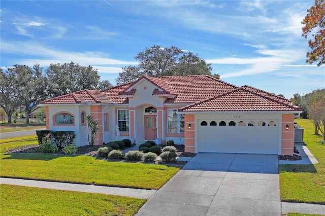 mediterranean / spanish-style home featuring a garage and a front lawn