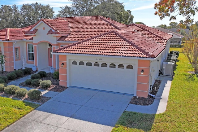 mediterranean / spanish-style house with central AC and a garage