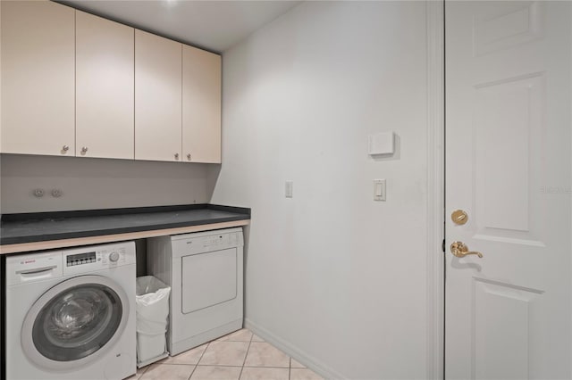 washroom featuring light tile patterned floors, cabinets, and independent washer and dryer