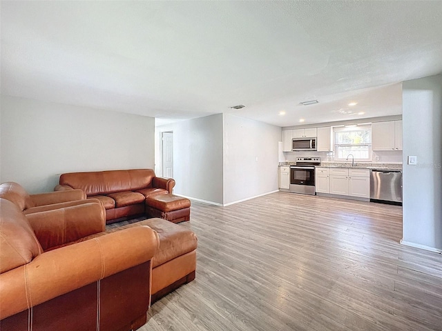 living room featuring light wood-type flooring and sink