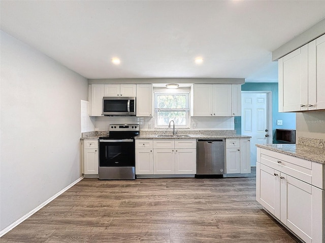 kitchen featuring white cabinets, appliances with stainless steel finishes, light hardwood / wood-style flooring, and sink