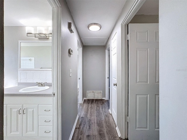 hall featuring sink and dark wood-type flooring