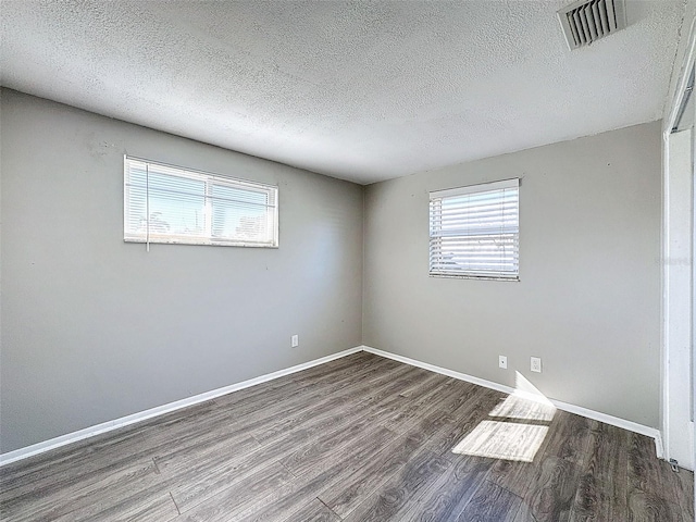 spare room with wood-type flooring and a textured ceiling