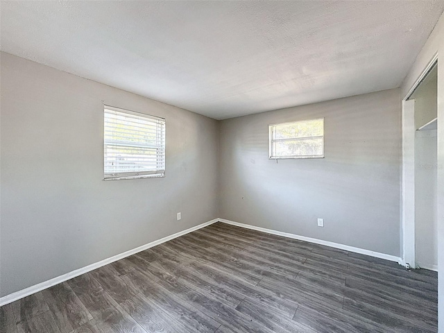 unfurnished room featuring a textured ceiling and dark hardwood / wood-style floors