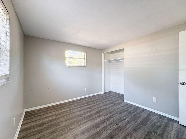 unfurnished bedroom with a closet and dark hardwood / wood-style flooring