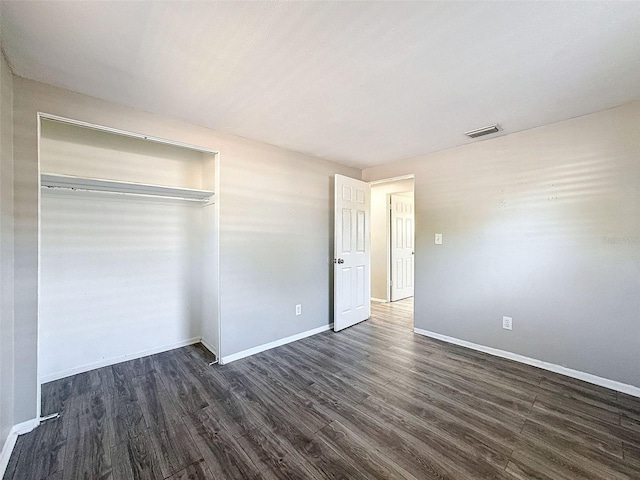 unfurnished bedroom featuring dark hardwood / wood-style flooring and a closet