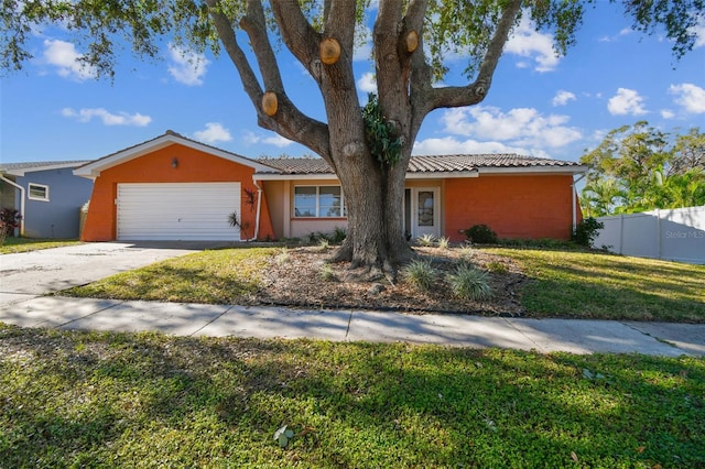 view of front facade with fence, a front yard, stucco siding, an attached garage, and driveway