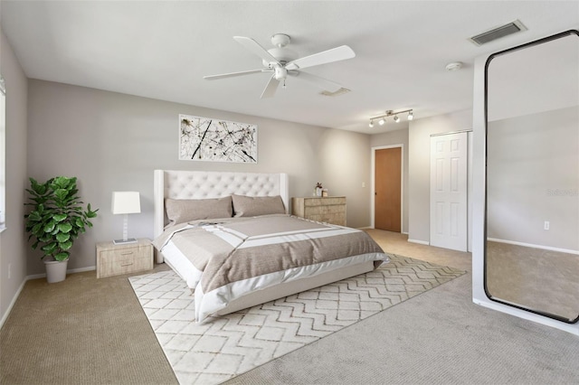 bedroom featuring a ceiling fan, baseboards, visible vents, and light carpet
