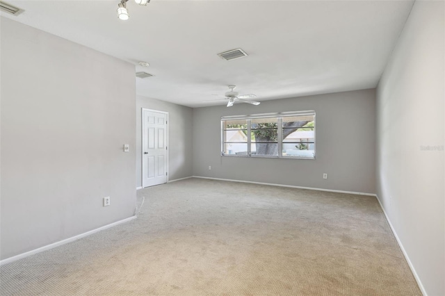 carpeted spare room featuring a ceiling fan, baseboards, and visible vents