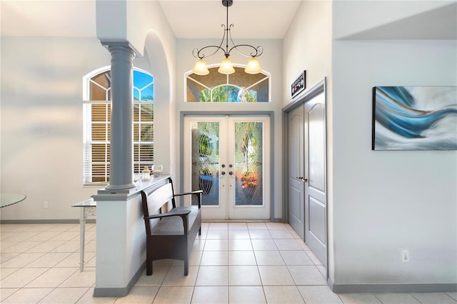 doorway with french doors, light tile patterned floors, a notable chandelier, and ornate columns