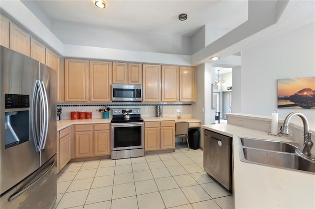 kitchen with light brown cabinets, backsplash, sink, stainless steel appliances, and a chandelier