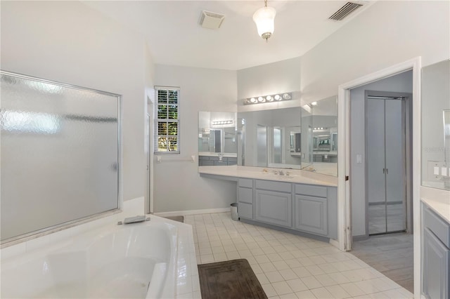 bathroom featuring vanity and a relaxing tiled tub