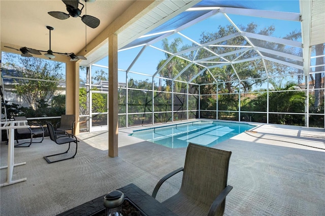 view of pool with glass enclosure, ceiling fan, and a patio