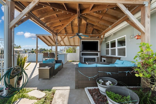 view of patio / terrace with an outdoor living space with a fireplace, ceiling fan, and a gazebo