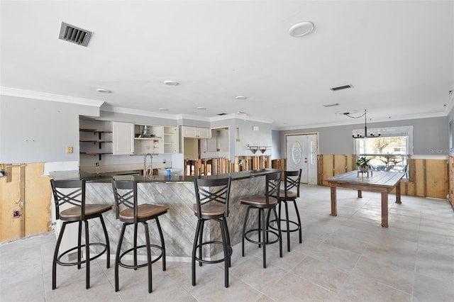 kitchen with kitchen peninsula, a kitchen breakfast bar, and ornamental molding