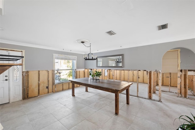 13610 Evelane Dr, Hudson, FL 34667 - tiled dining area with ornamental molding, wainscoting, arched walkways, and a chandelier