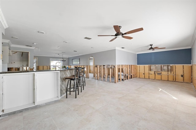 13610 Evelane Dr, Hudson, FL 34667 - kitchen with crown molding, a ceiling fan, recessed lighting, dark countertops, and a breakfast bar area