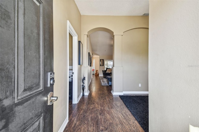 hallway with dark hardwood / wood-style flooring and a textured ceiling