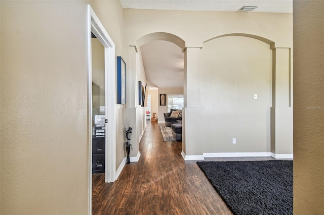 hallway featuring a textured ceiling and dark hardwood / wood-style flooring