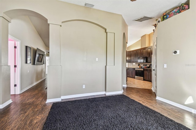 empty room featuring dark hardwood / wood-style flooring and vaulted ceiling