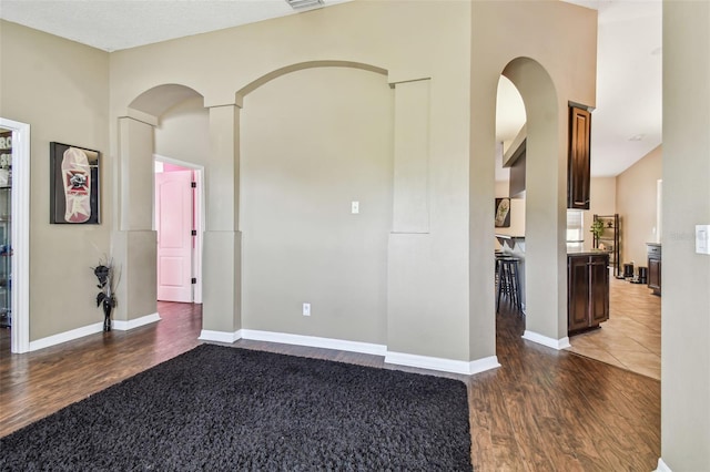 unfurnished room with a textured ceiling and dark hardwood / wood-style floors