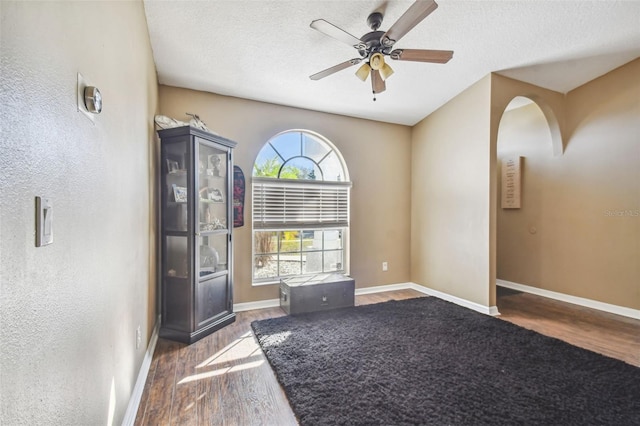 spare room with ceiling fan, dark hardwood / wood-style flooring, and a textured ceiling