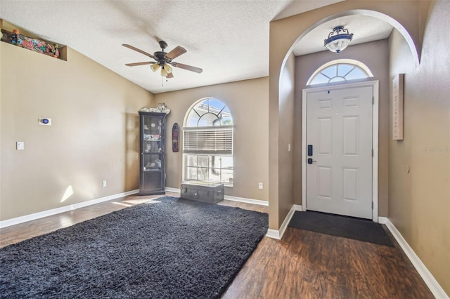 foyer with dark hardwood / wood-style flooring, a textured ceiling, and ceiling fan