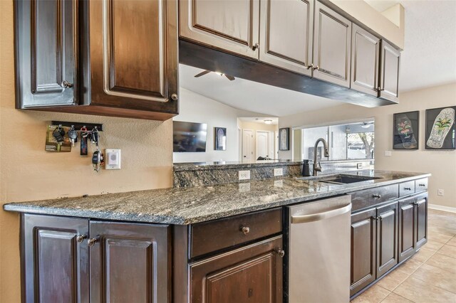 kitchen featuring dark stone countertops, ceiling fan, dark brown cabinets, and sink