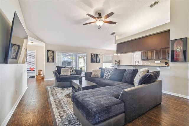 living room with ceiling fan, dark wood-type flooring, and a textured ceiling