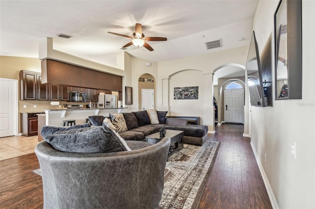 living room featuring ceiling fan, dark hardwood / wood-style flooring, and lofted ceiling