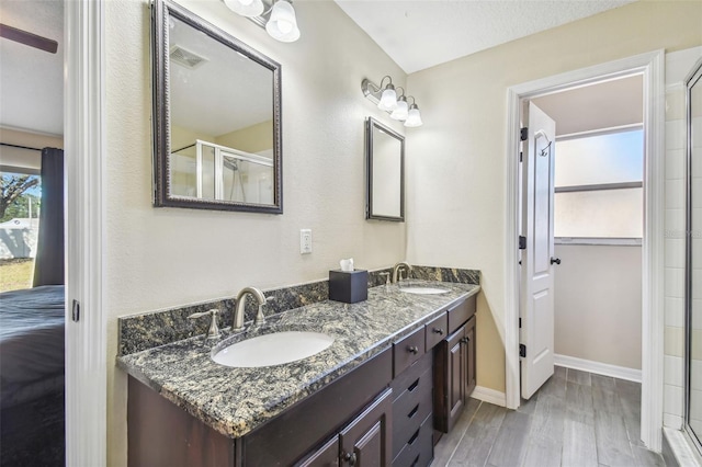 bathroom featuring walk in shower, vanity, a textured ceiling, and hardwood / wood-style flooring