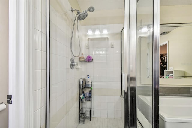 bathroom with toilet, tile patterned floors, and walk in shower