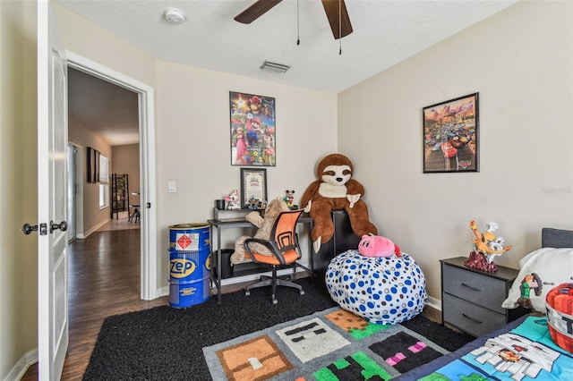 bedroom featuring ceiling fan, dark hardwood / wood-style floors, and a textured ceiling