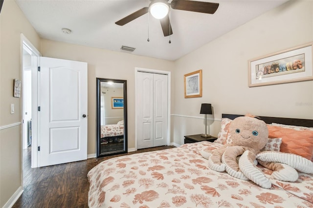 bedroom with ceiling fan, dark wood-type flooring, and a closet