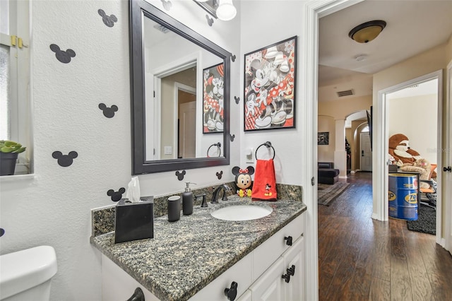 bathroom with hardwood / wood-style floors, vanity, and toilet