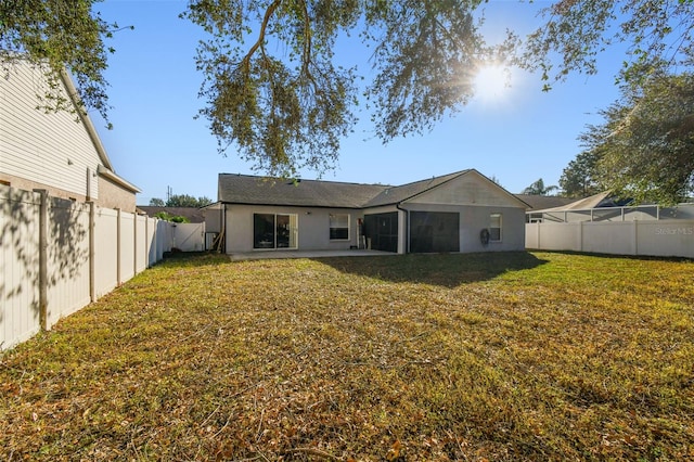 rear view of property featuring a yard and a patio