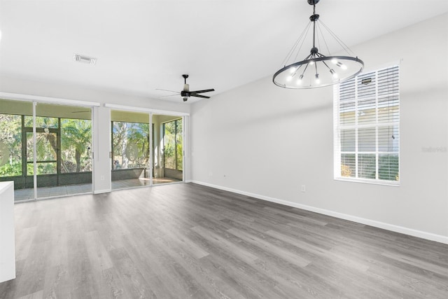 empty room with hardwood / wood-style flooring, plenty of natural light, and ceiling fan