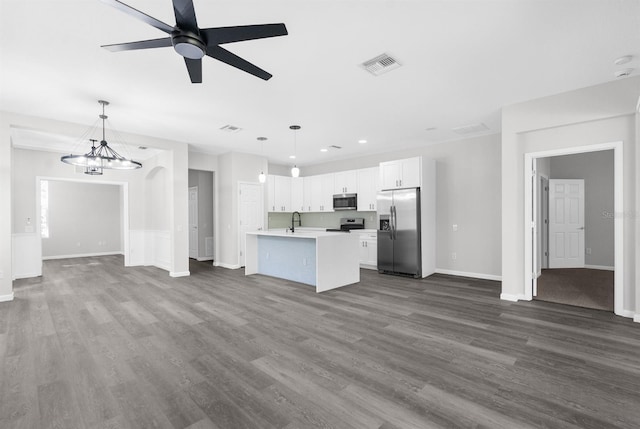 unfurnished living room featuring ceiling fan with notable chandelier, dark hardwood / wood-style flooring, and sink