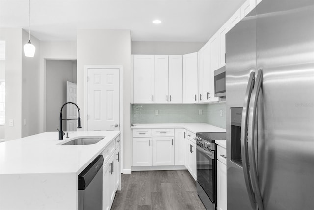 kitchen featuring pendant lighting, sink, appliances with stainless steel finishes, dark hardwood / wood-style flooring, and white cabinetry