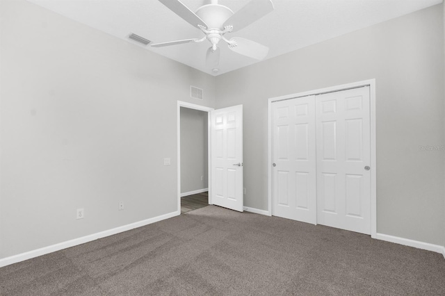 unfurnished bedroom featuring ceiling fan, dark carpet, and a closet