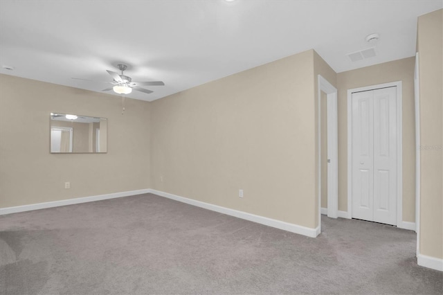 carpeted spare room with ceiling fan