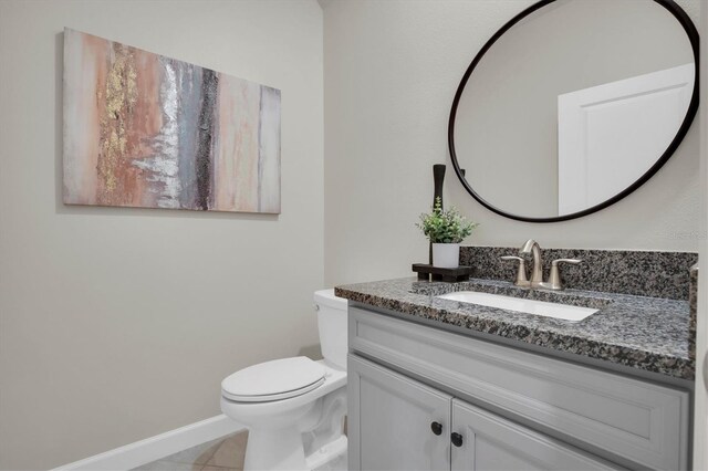 bathroom featuring tile patterned flooring, vanity, and toilet