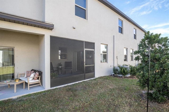 rear view of property featuring a sunroom and a yard